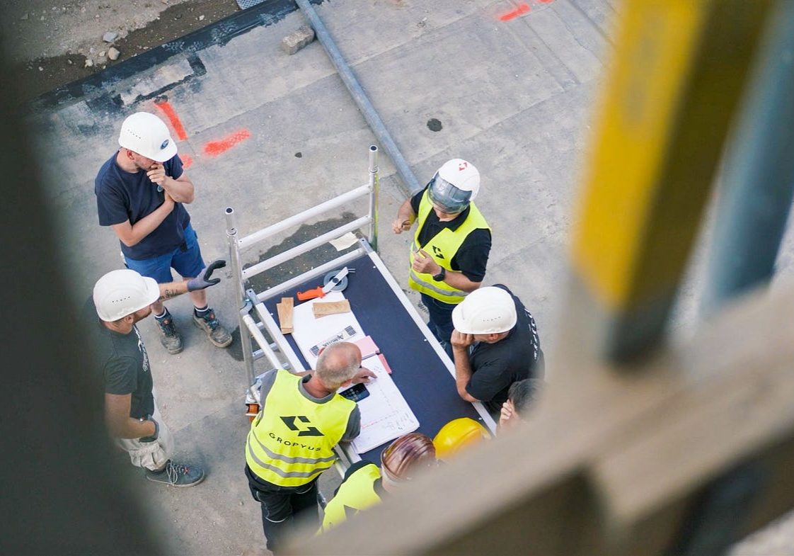 View from above of building workers standing around a table